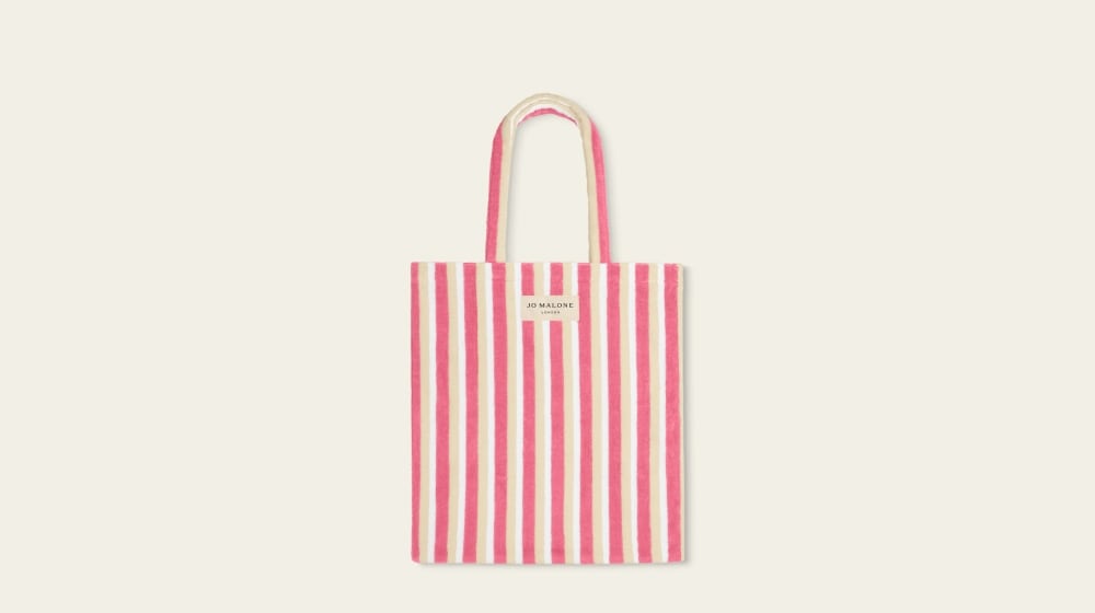 Una bolsa de regalo con rayas rosas tipo tote bag.